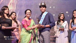 Student getting awarded as Mr. fresher at a college event