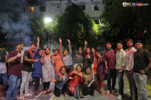 A large group of students throwing colors in the air during Holi at RCM.