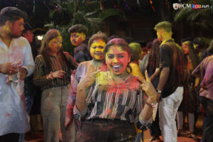 Students joyfully celebrating Holi with vibrant colors at RCM
