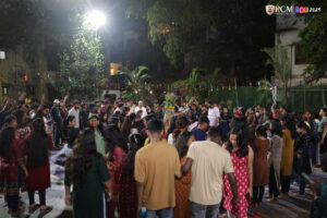 A cheerful group of students enjoying Holi festivities with music and dance.