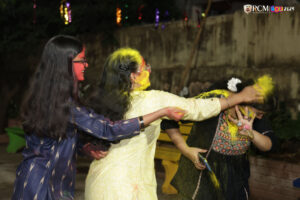 A vibrant Holi scene with students covered in festive colors at RCM.