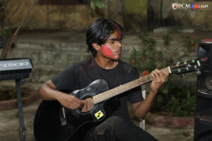 Live guitar performance adding melody to Holi festivities at RCM.