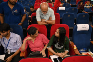 Judge evaluating participants' strategies during the high-stakes BID TO WIN financial simulation at RCM.