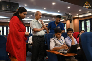 Judge evaluating participants' performance during the Bid to Win stock market simulation event at RCM.