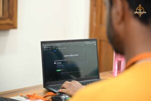 College festival participant focused on coding during HackForge x Build With AI at Brahmastra 2025 event.