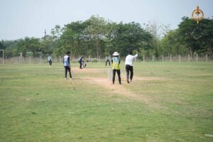 Cricket match in progress during Ranbhoomi at Brahmastra 2025 with players in action and crowd cheering at Railway Sports Complex.