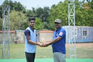 Faculty member shakes hands with a cricket player during Ranbhoomi at Brahmastra 2025