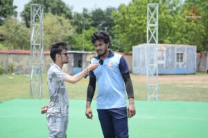 Event coordinator in discussion with a cricket player during Ranbhoomi at Brahmastra 2025, seeking match-related clarification.