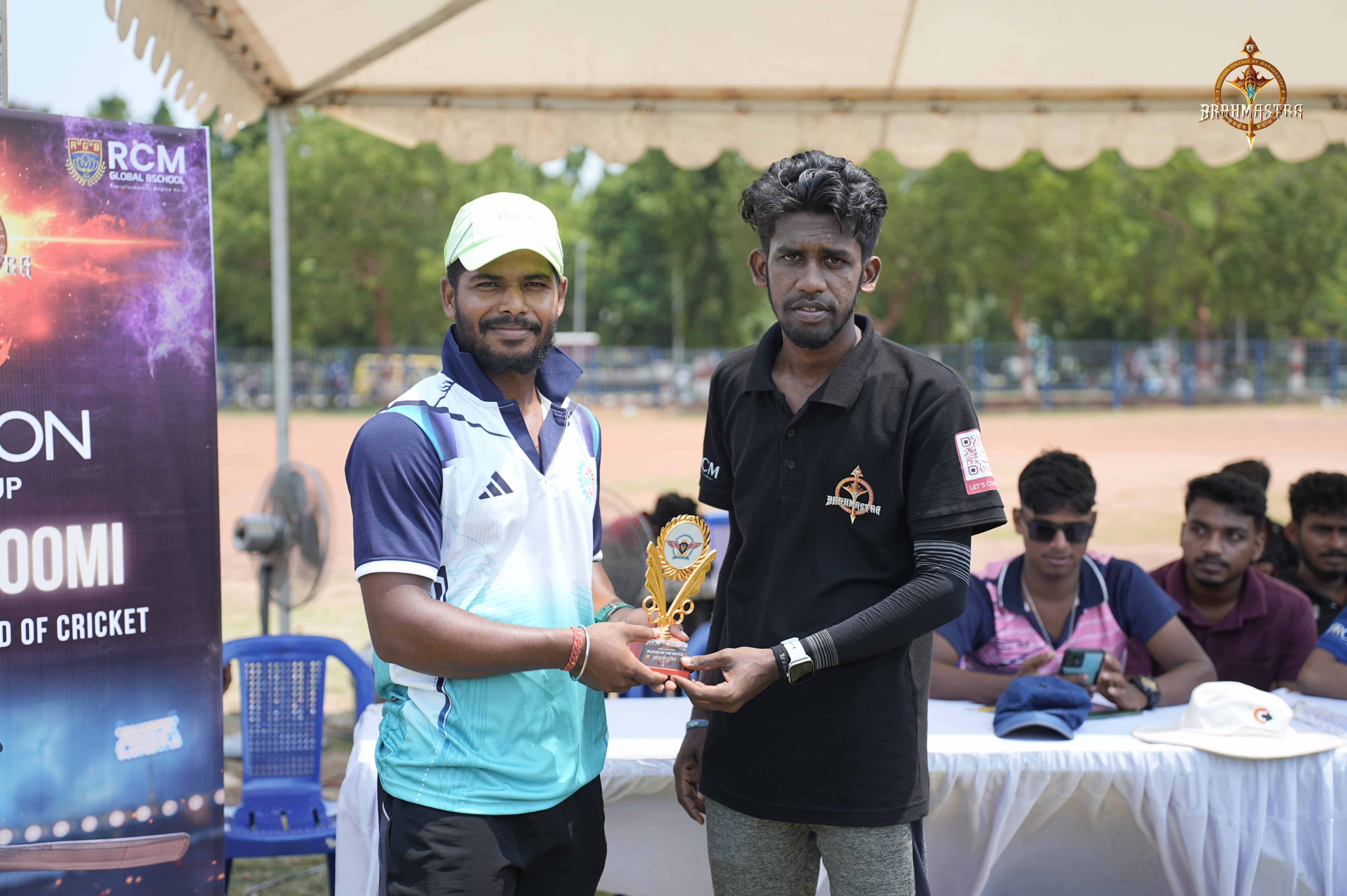 College cricket captain handing the Ranbhoomi (Cricket) tournament trophy to a player during the award ceremony at Brahmastra 2025.