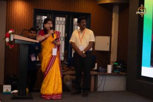 Female faculty addressing the audience during Navya Sopna at RCM, guiding student entrepreneurs.