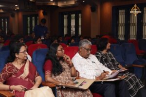 Judges and faculty observing presentations with microphones during Navya Sopna 2025 at RCM.