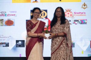 Women entrepreneurs receiving plants as a symbol of growth and sustainability at the Navya Sopna startup event.
