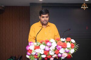 Faculty addressing participants on mic during the Navya Sopna entrepreneurial event at RCM.