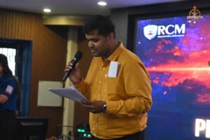 Faculty member addressing audience on stage during Navya Sopna at College Festival, Brahmastra 2025 celebration event.