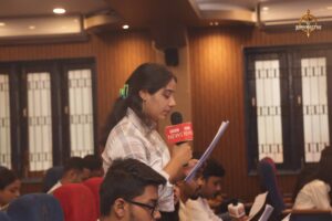 Student playing reporter interviews public figure role-player during Samvad Vivaad at Brahmastra college festival event.