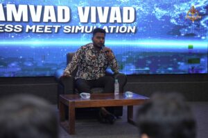 Student performing as public figure on stage during Samvad Vivaad at Brahmastra college festival in India.