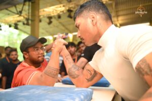 Two competitors arm wrestling at Brahmastra 2025 Kurukshetra event with crowd watching.