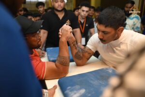 Two competitors in an intense arm-wrestling match at Brahmastra 2025 Kurukshetra event