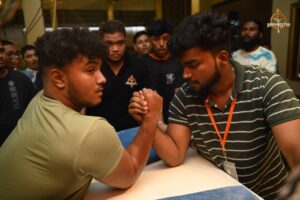 Two participants competing in Brahmastra 2025 Kurukshetra Arm Wrestling match on stage