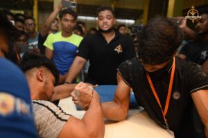 Arm-wrestling match at Brahmastra 2025 Kurukshetra event with crowd and stage lights