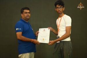 Certificate distribution ceremony at Brahmastra 2025 Kurukshetra Arm Wrestling event, with participants receiving certificates on stage from officials.