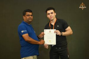 Certificate distribution ceremony at Brahmastra 2025 Kurukshetra Arm Wrestling event with participants receiving certificates on stage.