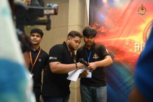 Two young men engaged in conversation in an intense arm wrestling competition during Brahmastra 2025 at Regional College of Management, Bhubaneswar.