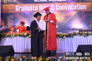 Graduate receiving certificate at RCM Graduation Day 2K25 ceremony for MBA and MCA programs.