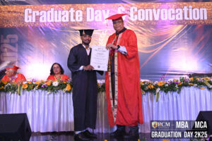 A graduate receives a certificate on stage during Graduate Day & Convocation at RCM 2025.