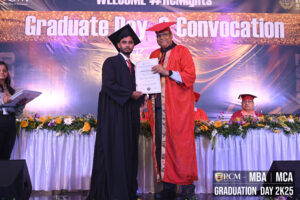 Graduation ceremony with graduate in black gown receiving certificate from person in red gown.