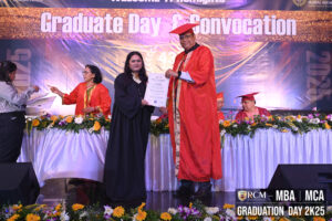 Graduation ceremony with certificate presentation, banner reads Graduate Day and Convocation.