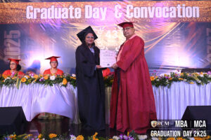 Graduate receiving certificate on stage at RCM Graduate Day & Convocation event.