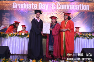 Graduate receiving certificate from two individuals in red robes at a convocation ceremony.