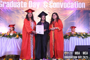 Graduate in cap and gown receiving a certificate on stage during a convocation ceremony.