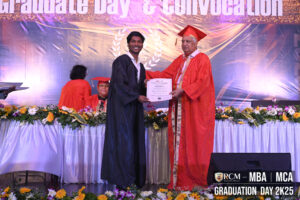 Graduate receives certificate from faculty at RCM MBA/MCA 2025 graduation ceremony.