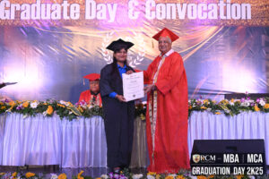 Graduate receives diploma at Regional College of Management MBA/MCA ceremony with decorations.