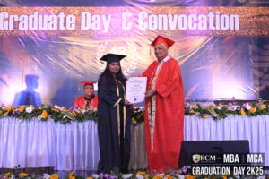 Graduate receiving diploma from official at RCM Graduation Day 2K25 ceremony.