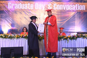Graduate receiving diploma on stage at RCM Convocation Day 2K25 event.