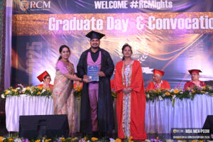 Graduation ceremony with certificate presentation, floral decor, and backdrop text "Graduate Day & Convocation."