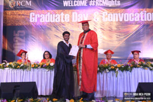 Graduation ceremony at Regional College of Management 2025 with people in academic attire.