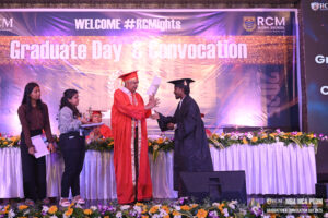 Graduation ceremony at RCM Global School with diploma handover on stage.