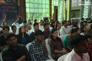 People seated at indoor graduation event for RCM's BBA and BCA class of 2025, attentive audience.