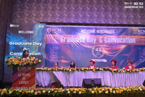 RCM Graduate Day and Convocation 2025 event with speaker and academic regalia.