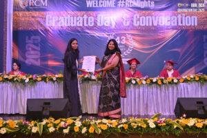 Graduation ceremony at Regional College of Management, 2025; certificate presentation on stage.
