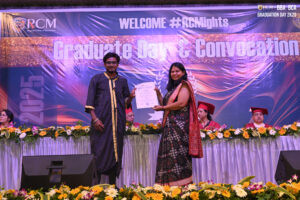 Graduate in black gown receives certificate from woman on stage at 2025 convocation ceremony.