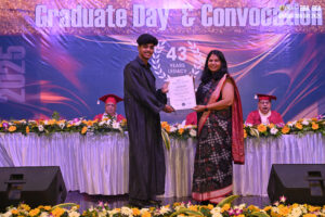 Graduation ceremony with student receiving a certificate on stage; "Graduate Day & Convocation."