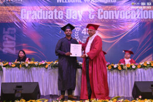 Graduation ceremony with a student receiving a certificate on a decorated stage, 2025 backdrop.