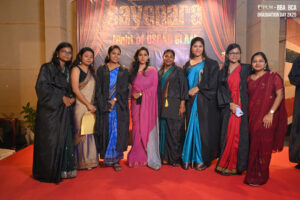 Nine individuals in sarees and gowns on red carpet, "Sayonara" backdrop, Graduation Day 2K23.