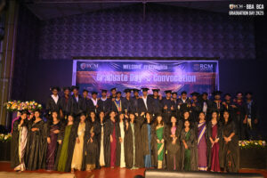 Graduates in caps and gowns on stage during "Graduate Day & Convocation" ceremony.