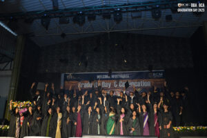 Graduates in caps and gowns celebrate by throwing caps at "Graduation Day & Convocation" event.